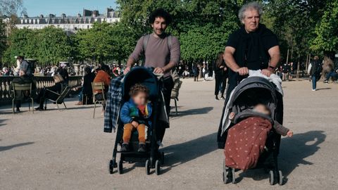 Dos hombres pasean con sus hijos en los carritos por los Jardines de Luxemburgo, en Par&iacute;s
