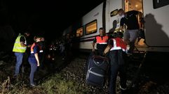 Personal de emergencias ayuda a los viajeros a bajar del tren accidentado