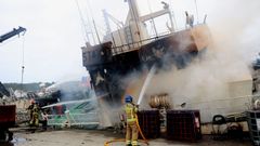 Personal del GAEM de Ribeira y de los bomberos, sofocando el fuego desde el exterior.