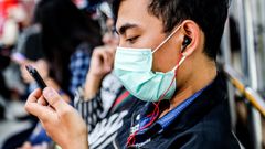 Un chico se protege con una mascarilla mientras viaja en un autob�s de Medan, Indonesia.