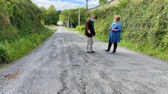 El alcalde muestra los baches que proliferan en la carretera a la diputada Carme Aira