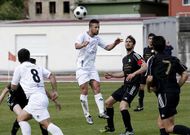 Kike, en el centro, despeja de cabeza un bal�n en el campo municipal de A Pinguela.