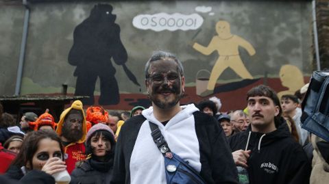 Un hombre reci�n atrapado por el Oso, delante de un mural sobre el carnaval de Salcedo