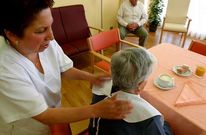 Una cuidadora atiende a una persona dependiente en un centro de d�a de una localidad gallega.