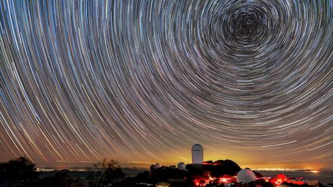 DESI cartografa objetos muy distantes para estudiar la energa oscura. El instrumento est instalado en el telescopio Mayall, que se muestra en esta imagen bajo las estelas de las estrellas.