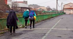 Peregrinos en un tramo del Camino Portugu�s sin aceras en el casco urbano de Padr�n.
