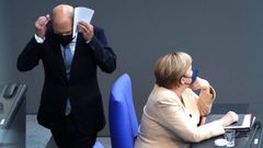 Scholz pasa por detrs de Merkel, en la sesin del Bundestag el pasado martes.