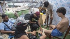Inmigrantes jugando a las damas en una playa de Ceuta.