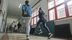 Alumnos de secundaria haciendo Educación Física en los pasillos de un instituto