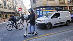 Una bicicleta y un patinete el�ctrico circulan correctamente por la calzada en una calle del centro de Pontevedra 