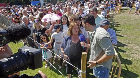 Un equipo de televisión entrevista a una mujer que asistió a la carrera entre el público
