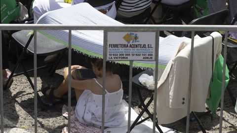 Una ni�a cubri�ndose del sol durante la misa.