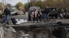 Una familia cruza junto a un puente da�ado en la ciudad liberada de Kipiansk, en el este de J�rkov