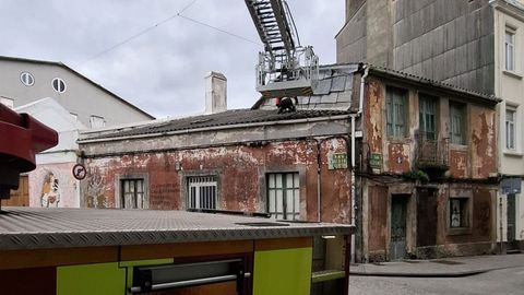 Actuación de los bomberos en el tejado de una casa en el Cruceiro de Canido