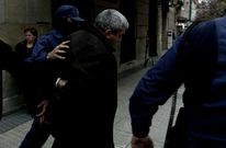 Uno de los detenidos es escoltado durante un registro en una taper�a de Vigo en el 2004.