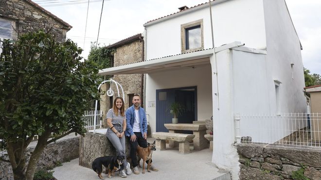 El santiagu&eacute;s Alejandro Pereiro, de 35 a&ntilde;os, y la lucense Elena Veres, de 34, junto a la vivienda que rehabilitaron en el n&uacute;cleo de Seaxe, en Rois