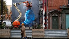 Un artista trabaja en Manchester en un mural sobre el coronavirus