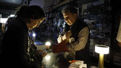 Persoas comprando lanternas o d�a do apag�n.