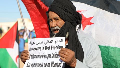 Un hombre sostiene un cartel en el que reclama la autodeterminaci�n del S�hara Occidental durante una manifestaci�n en los campamentos de refugiados de la regi�n argelina de Tinduf