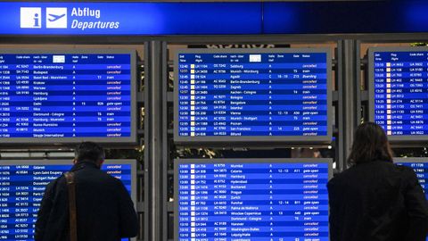 Usuarios consultando el estado de sus vuelos en el aeropuerto de Fr&aacute;ncfort.