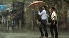 Peatones indios protegi�ndose con su paraguas de la fuerte lluvia en Mumbai, India