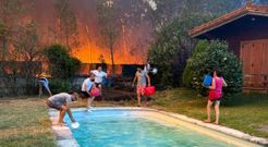 Vecinos intentando luchar contra las llamas cogiendo agua de su piscina