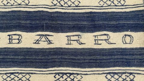Detalle do cobertor de la elixido como imaxe da exposici�n que luce cosido o nome de �Barro�, e que data do s�culo XIX, o rexistro familiar da palabra �Barro� m�is antigo que o dese�ador conserva e que alude ao seu bisav� Nicol�s Barro, comerciante de tecidos en Pontedeume.
