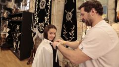 En la imagen, L�a, de 11 a�os, probando la t�nica y la capa con la que este viernes Santo se estrenar� como hach�n en la procesi�n de la Pasi�n, en la�su padre es �levador� del paso de la Piedad