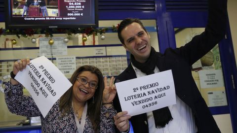 Marcos Delgado, due�o de la administraci�n de loter�a ubicada en la calle Condesa de Venadito, en Madrid, acompa�ado de la vendedora Jenyffer Hoyos celebran el segundo premio, que ha reca�do en el 04536, vendido en parte en esta administraci�n