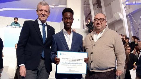 El presidente de la Xunta, Alfonso Rueda, con Ibrahima Diambang y Jess Iglesias, directivo del centro de menores San Anbal de Burela. El joven estudia un ciclo de Coidados Auxiliares de Enfermera en el IES Monte Castelo tras haber acabado la ESO en el IES Perdouro