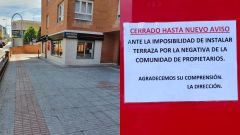 A la derecha, el cartel del cierre del bar de Gij�n hasta nuevo aviso por la negativa de los vecinos y, a la izquierda, el espacio disponible en la acera 