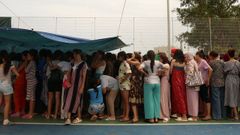 Migrantes mujeres y ni�as, esperando este mi�rcoles por su turno de recogida de comida.