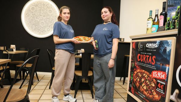 Empleadas del establecimiento con una Pizza Curtas reci�n hecha y el bote de salsa especial empleado para redondear su sabor.