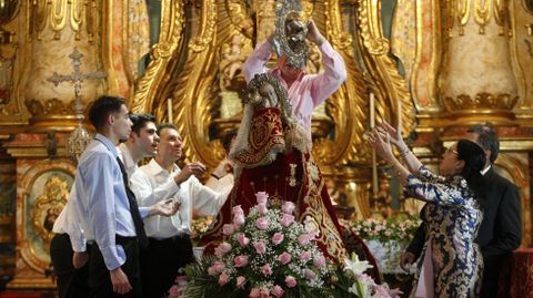 Un cofrade le retira la corona a la Virgen de Montserrat al final de la procesión, para comprobar el alcance de los daños que sufrió la imagen en su caída
