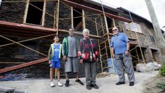 Emilio R�o y Carmen Marcos con su hijo y su nieto, frente a una de las casas a�n en reconstrucci�n