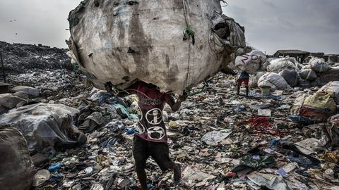 Fotograf�a cedida por la organizaci�n World Press Photo que muestra la imagen captada por el fot�grafo Kadir van Lohuizen, ganador del primer premio de la categor�a �Environment - Stories�. La foto muestra a un hombre mientras carga un enorme lomo de botellas recogidas para su reciclaje en el vertedero de Olusosun en Lagos, Nigeria, el 21 de enero del 2017
