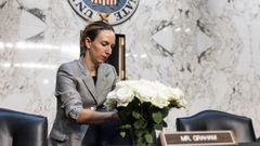 Una funcionaria deja flores en el esca�o de Graham.