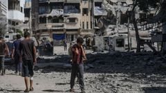 Civiles palestinos caminan por una zona destruida tras los ataques areos israeles en la ciudad de Gaza.