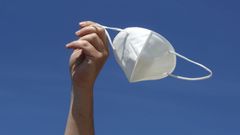 Un mozo sost�n unha m�scarilla o aire o d�a que cambia a normativa do seu uso en esteriores