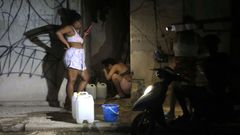 Persoas enchen recipientes con auga durante un apag�n o xoves pasado na Habana