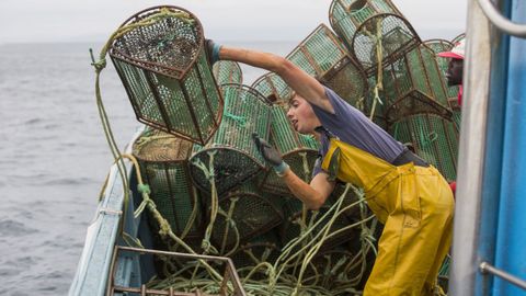 Un tripulante de un pesquero de Malpica lanzando nasas de pulpo al mar (foto de archivo)