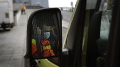 El conductor de una ambulancia se coloca la mascarilla contra el covid en la rampa de acceso a Urgencias del Chuac