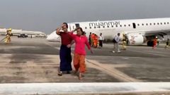 Dos mujeres abandonan el avin sinistrado mientras operan los servicios de emergencias.