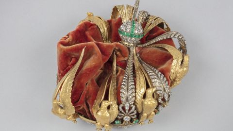 Originalmente, la corona presentaba ocho palmetas de diamantes y esmeraldas, alternadas con ocho �guilas de oro. Ahora falta una de las �guilas.