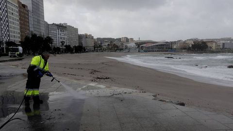 Un operario, esta ma�ana limpiando la arena en el paseo