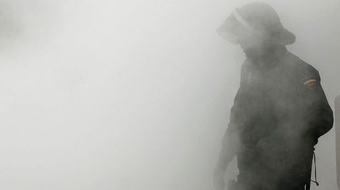 Un polic�a nacional envuelto en el humo provocado por la quema de un contenedor, durante un incidente ocurrido en Pamplona en el 2013