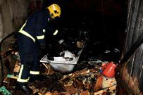 Un bombero trabaja entre los restos del incendio.