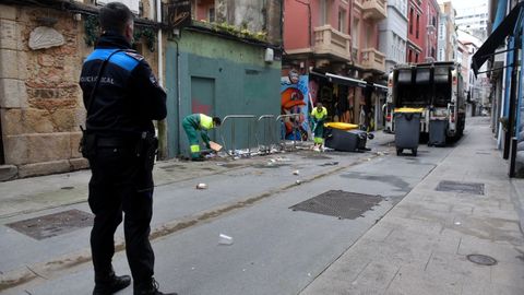 Un agente del 092 escolta a uno de los camiones que recogen basura en el entorno del Orz�n