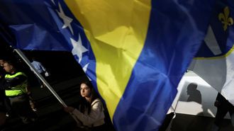 Una simpatizante del SDA bosnio ondea una bandera del pa�s.