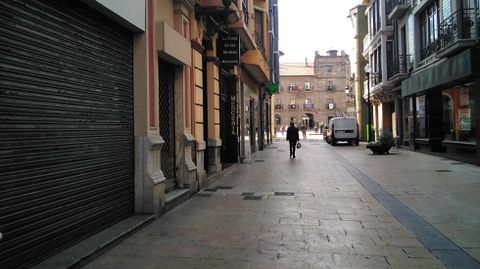 Varios locales permanecen con la persiana bajada y carteles de alquiler en unos metros de la calle La Fruta, en el centro de Avil�s.